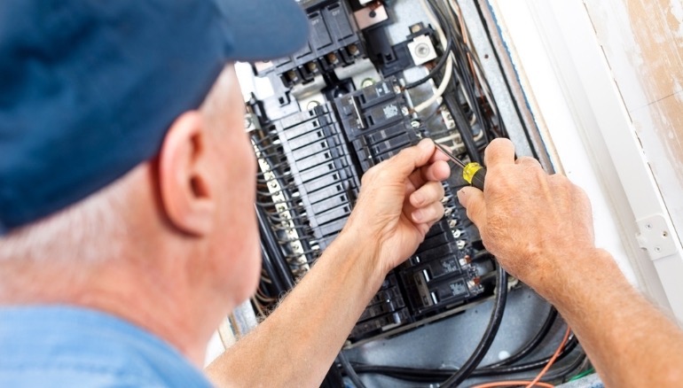 Electrician Working On a Breaker Box- Licensed, Bonded, and Insured- Get Free Estimates