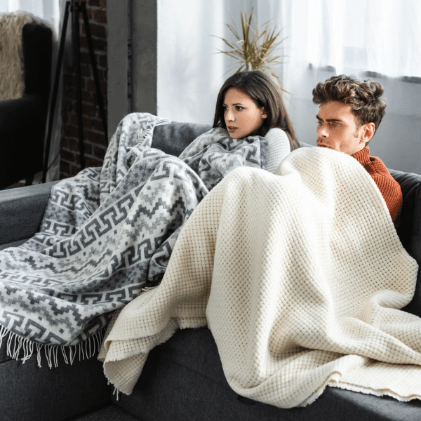 Homeowner feeling cold in a living room despite the heat running